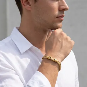 Men's gold stainless steel 5mm wheat chain bracelet worn with a white linen shirt.