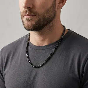 Detail view of 5mm black stainless steel dragon bone chain necklace worn by a male model