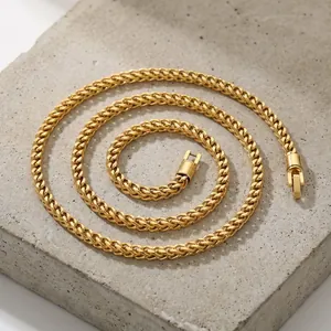 Close-up detail of a 5mm golden stainless steel keel chain necklace on a stone base.