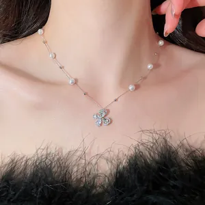 Close-up of elegant pearl and crystal floral pendant necklace on model's neck.