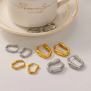 Detail view of irregular wrinkled stainless steel hoop earrings in gold and silver