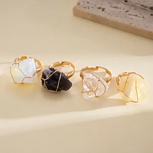 Detailed view of four unique gold wire wrapped rings with natural raw crystals