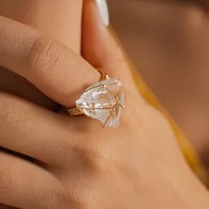 Close-up detail of a handmade wire wrapped ring featuring a natural raw clear crystal stone