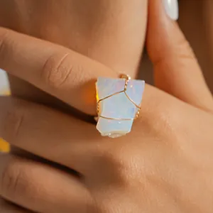 Close-up of a handmade gold wire-wrapped ring with a natural translucent opal raw stone