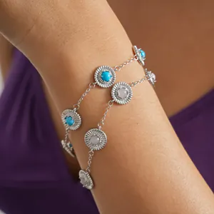 Primer plano de una pulsera retro plateada con dijes redondos de resina azul y blanca