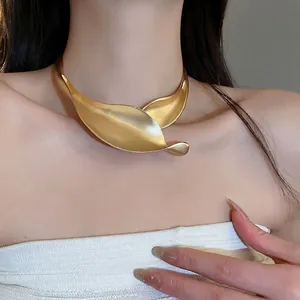 Girocollo rigido in metallo dorato opaco a forma di foglia su modella