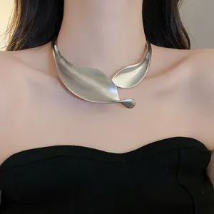 Dettaglio ravvicinato di un girocollo metallico minimalista in argento opaco a foglia su modella