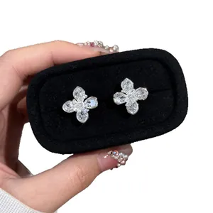 Sparkling silver clover flower stud earrings with clear zircon stones in a black box