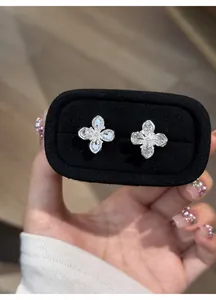 Close-up of sparkling silver clover flower stud earrings set with clear cubic zirconia