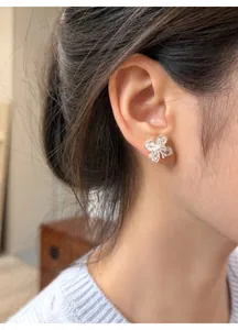 Detailed view of an elegant silver four-leaf flower stud earring with clear zircon