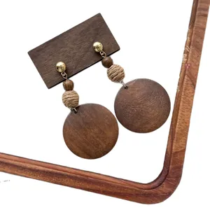 Orecchini etnici in legno con dischi tondi geometrici e perline intrecciate.