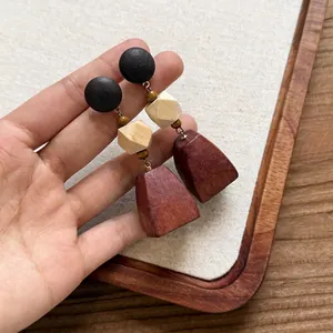 Primo piano dettagliato di orecchini geometrici in legno fatti a mano in tre colori