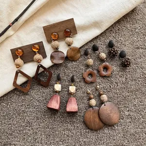 Collezione dettagliata di orecchini vintage in legno con motivi a fiori e cerchi