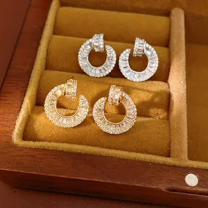 Close-up of gold and silver plated 18k stud earrings with baguette CZ inlay