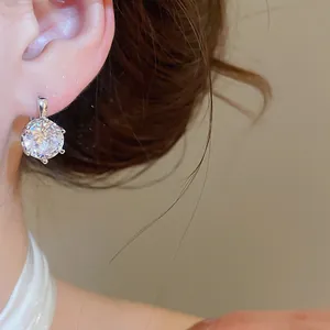 Close-up of a sparkling round zirconia earring worn on a model's ear