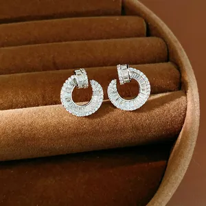 Macro view of circular zirconia stud earrings in a brown velvet jewelry display box