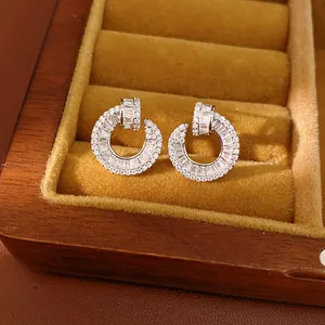 Close-up detail of 18k gold-plated silver stud earrings with sparkling circular zirconia