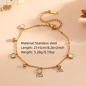 Detailed macro view of a gold titanium steel anklet featuring white charms and crystals
