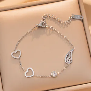 Gedetailleerde macro-opname van zilveren titanium stalen armband met hart en vleugel.