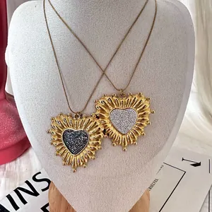 Detailed close-up view of vintage gold sunflower heart pendant necklaces with zircons.
