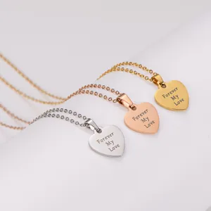 Macro detail of three engraved heart necklaces in silver, gold, and rose gold.