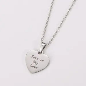 Close-up macro detail of stainless steel heart pendant with Forever My Love engraving