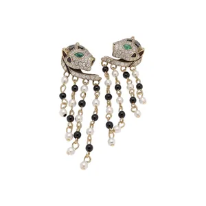 Vintage leopard head stud earrings with dangling pearls and black beads on white bg