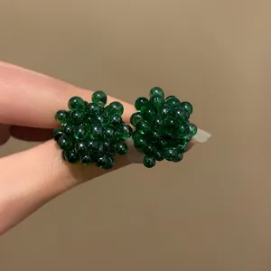 Vista dettagliata di orecchini a grappolo verde scuro con perline trasparenti