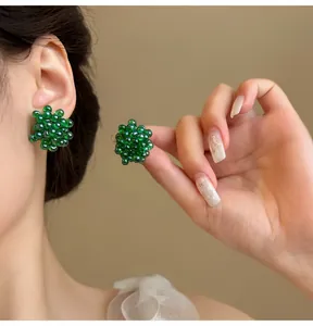 Primo piano dettagliato di orecchini a grappolo d'uva verde con perle lucide.