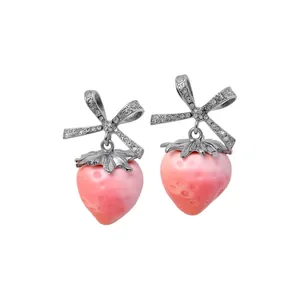 Sweet pink strawberry drop earrings with sparkling rhinestone bow knots on white background