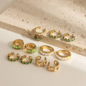 Close-up detail of luxury gold stainless steel ear cuff set with green zircon and pearls.