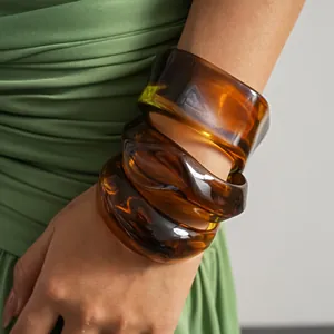 Amber acrylic geometric bangle set with irregular marbled texture on wrist