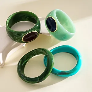 Dettaglio di bracciali geometrici in acrilico con esclusivi motivi marmorizzati
