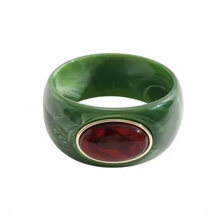 Elegante bracciale in acrilico marmorizzato verde con resina ambra e bordo dorato