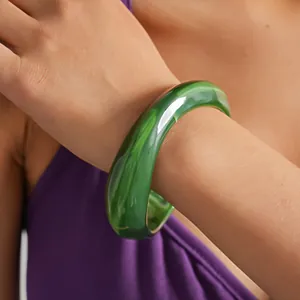 Vista dettagliata del bracciale in acrilico marmorizzato verde geometrico al polso