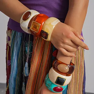 Detailed shot of model wearing colorful chunky acrylic geometric bangles in vintage style