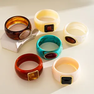 Collection of vintage acrylic bangles with embedded geometric stones and gold trim
