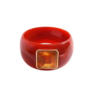 Retro red acrylic chunky bangle featuring a square amber resin detail in a gold frame.