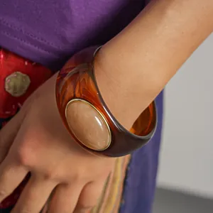 Detailed macro view of a retro acrylic gradient bangle with a large beige stone inlay