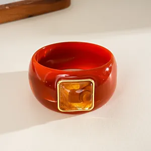 Macro shot of a vintage acrylic square bangle with an amber-colored inlay.