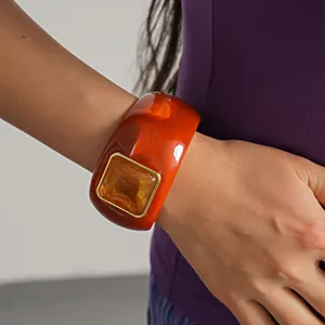 Close-up detail of a vintage amber acrylic bangle with a square geometric centerpiece decoration