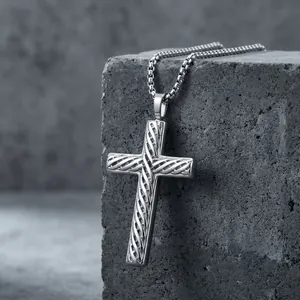 Detailed close-up of a silver stainless steel cross pendant with twisted diagonal pattern