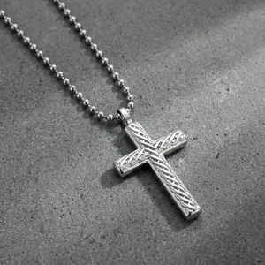 Close-up of hip-hop style stainless steel cross pendant with diagonal weave pattern.