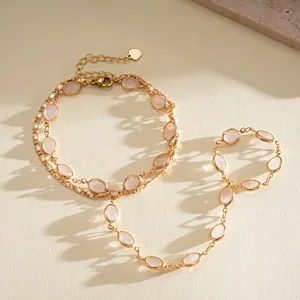 Close-up of an elegant double-layer gold chain bracelet with pink oval resin beads.