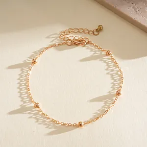 Detailed view of an elegant gold bead chain bracelet with an adjustable lobster clasp closure