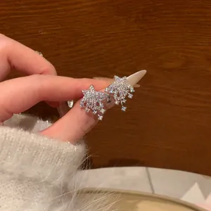 Detailed close-up showing sparkling silver star earrings with dangling cubic zirconia stones