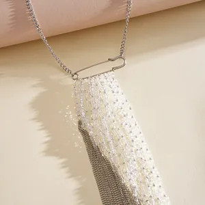 Close-up of a safety pin tassel necklace with clear glass beads and silver chains.