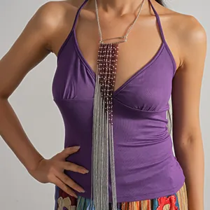 Close-up of a long fringe necklace with glass beads and metal chains on a model