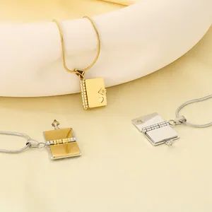 Detaillierte Ansicht von Buch-Medaillon-Halsketten in Gold und Silber mit Herz-Design.