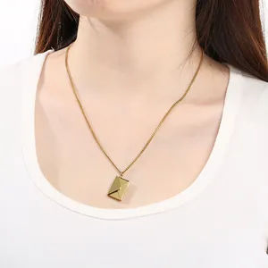 Nahaufnahme einer minimalistischen goldenen Umschlag-Halskette am Schlüsselbein eines Models